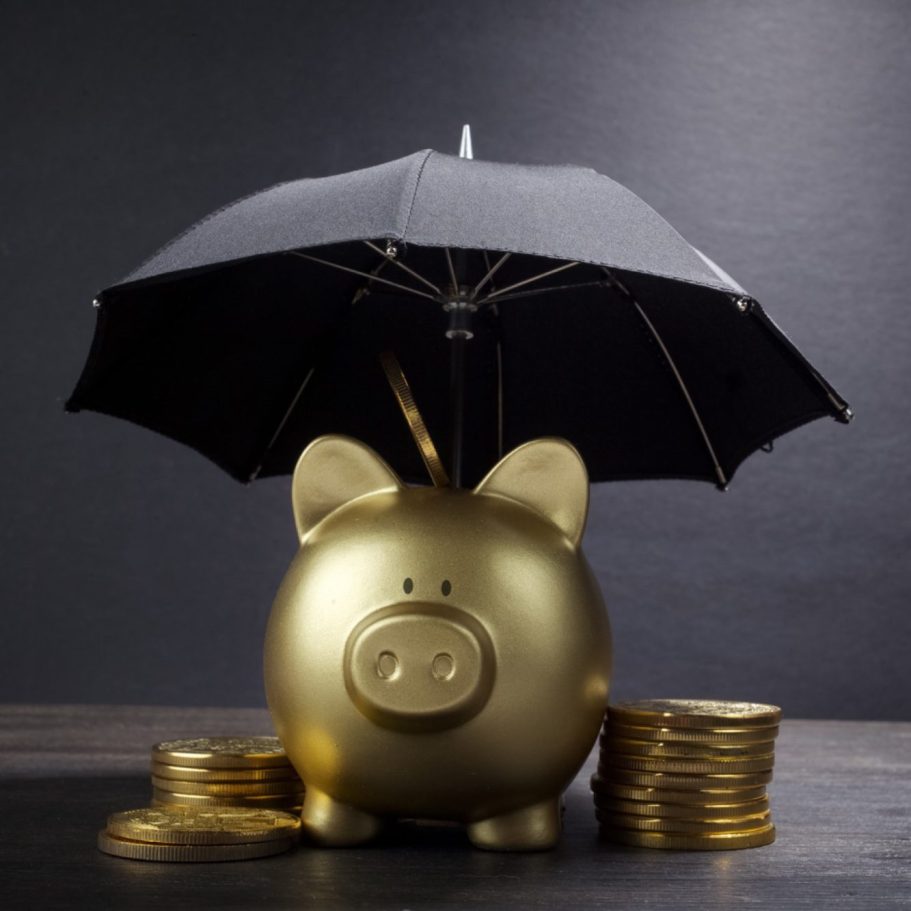 goldenes Sparschwein mit Münzen und Regenschirm goldenes Sparschwein mit Münzen und Regenschirm